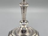 a silver plated candle holder sitting on top of a table