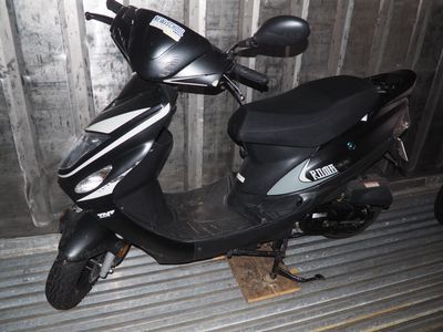un scooter garé contre le mur d'un immeuble