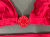 a close up of a red bikini top with a button on it