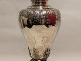 a silver urn with a red rose on it