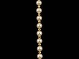 a close up of a pearl necklace on a black background