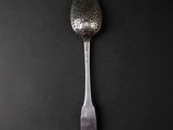 a spoon that is sitting on top of a black table