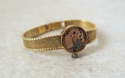 an image of a close up of a gold ring with a clock on it