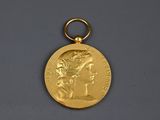 une image représentant une médaille d'or sur laquelle figure la tête d'une femme