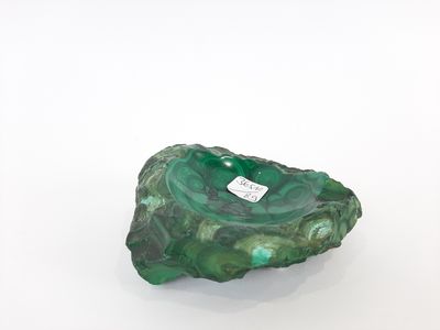 un marbre vert et blanc sur lequel est posée une étiquette, posé sur une surface blanche