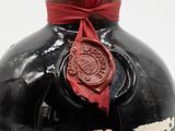 a bottle of liquor with a wax seal on it