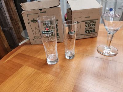 deux verres posés sur une table à côté d'un carton de bière