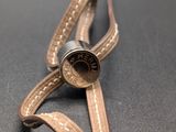 a leather strap with a button on it on a black surface