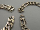 trois bracelets en argent posés les uns à côté des autres sur une table