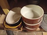 three bowls sitting on top of a wooden shelf