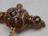 une broche en forme de tortue en or, ornée de motifs bleus et blancs