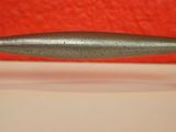 a close up of a metal handle on a white counter