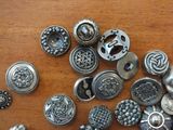 a lot of metal buttons on a wooden table