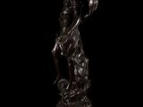a bronze statue of a woman holding a bird on a pedestal
