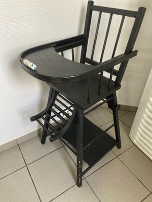 une chaise haute noire avec un plateau dessus