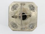 an antique silver box with a cross on it on a white surface