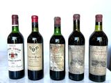 several bottles of wine are lined up on a marble table