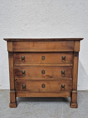 une vieille commode en bois posée sur un sol en ciment