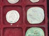 several different types of coins in a red box on a table