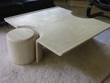une table basse sur laquelle est posé un tabouret, dans un salon