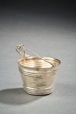 silver plated bucket with a spoon in it on a gray surface