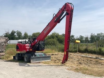 a red crane that is standing in the dirt