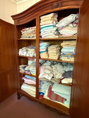 a cabinet with a lot of folded clothes in it