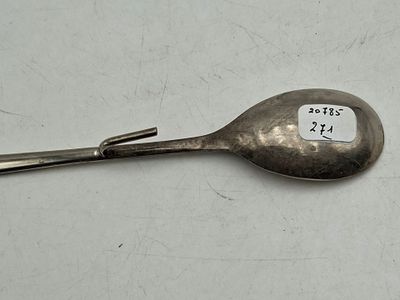 une cuillère sur laquelle est collé un autocollant, posée sur une table