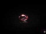 a close up of a pink diamond on a black surface