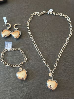 a close up of a necklace, bracelet, and ring on a table