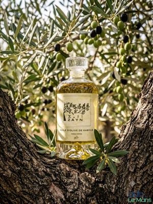 a bottle of olive oil sitting on top of a tree branch