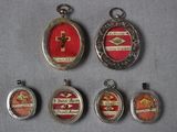 plusieurs pendentifs en verre argenté et rouge disposés sur un fond gris