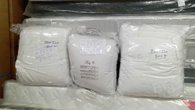 many bags of mattresses and pillows stacked on top of each other