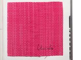 un livre ouvert sur lequel est posé un morceau de tissu rose