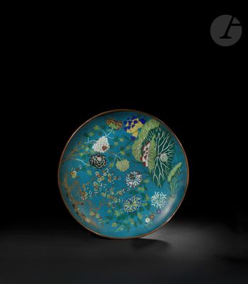 une image représentant une assiette bleue et verte ornée de fleurs