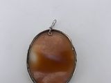 an oval pendant with a brown stone in the center