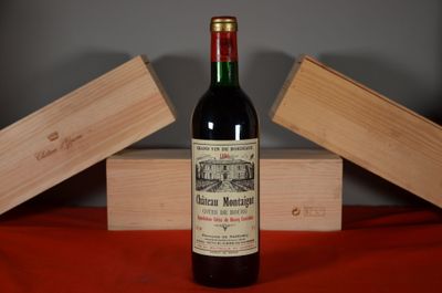 a bottle of wine sitting on a table next to a wooden box