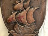 an image of a wooden plaque with a ship on it