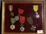 une photo d'un cadre contenant des médailles et des décorations