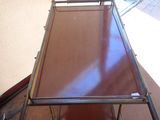 a metal table with a glass top on a wooden floor