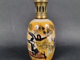 une image représentant un vase jaune orné d'une peinture en noir et blanc