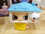 a small doll that is sitting on the floor next to a doll house