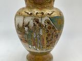 a gold vase with a painting on it on a white background
