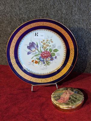 une assiette sur laquelle est représentée une horloge, à côté d'une boîte