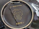 a close up of a black plate with a gold emblem on it