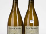 deux bouteilles de vin posées l'une à côté de l'autre sur une surface blanche