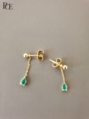 une paire de boucles d'oreilles en or ornées de pierres vertes