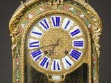 a gold clock with blue and white decorations on it