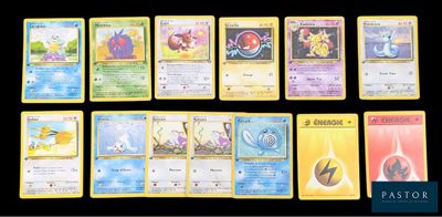 Plusieurs cartes Pokémon sont alignées sur une surface noire