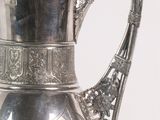 a silver pitcher that is sitting on a table